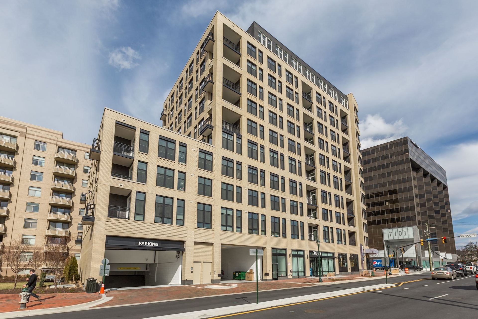 A large building with a parking garage in front of it at Solaire 7077 Woodmont in Bethesda, MD.