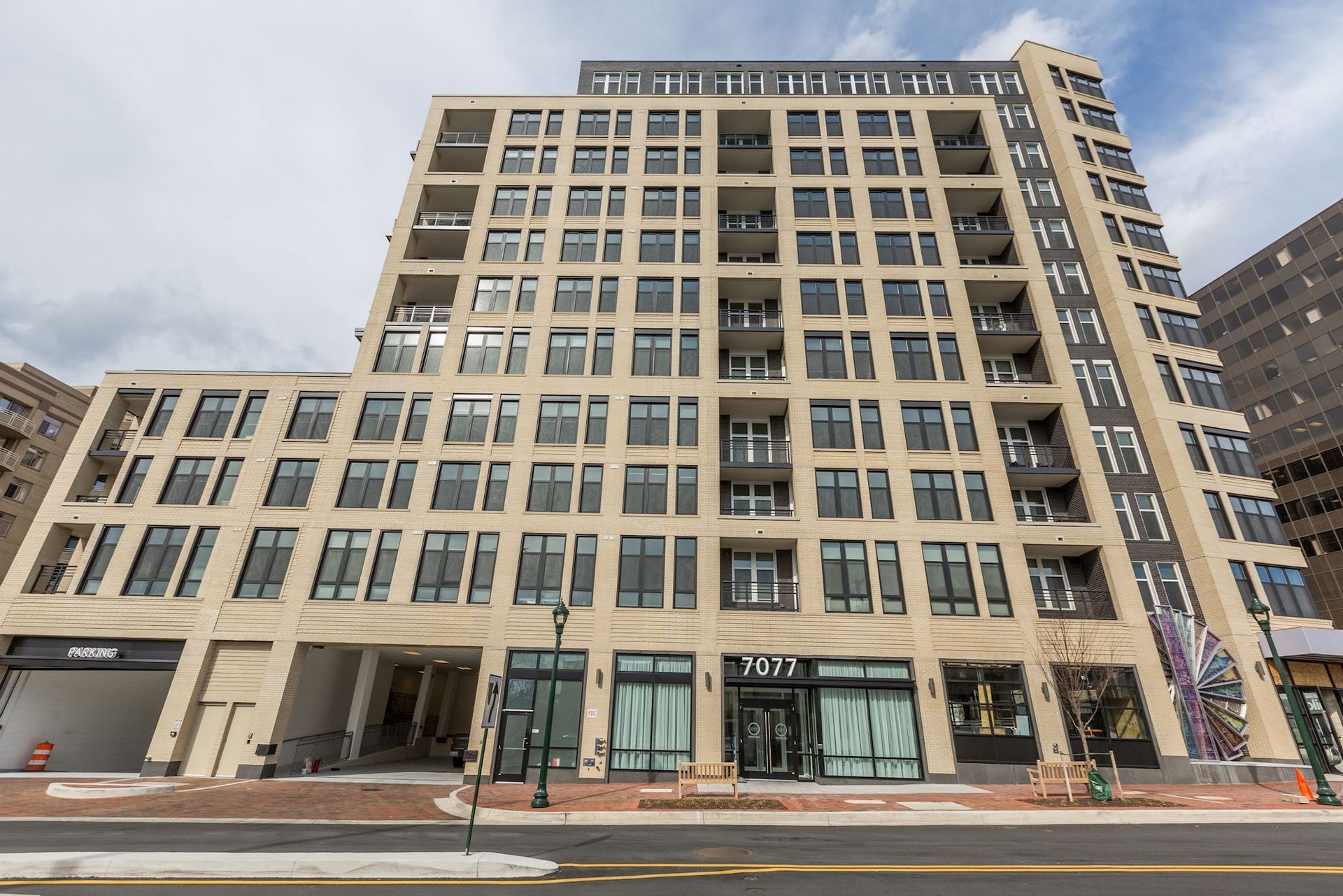 A large building with a parking garage in front of it at Solaire 7077 Woodmont in Bethesda, MD.