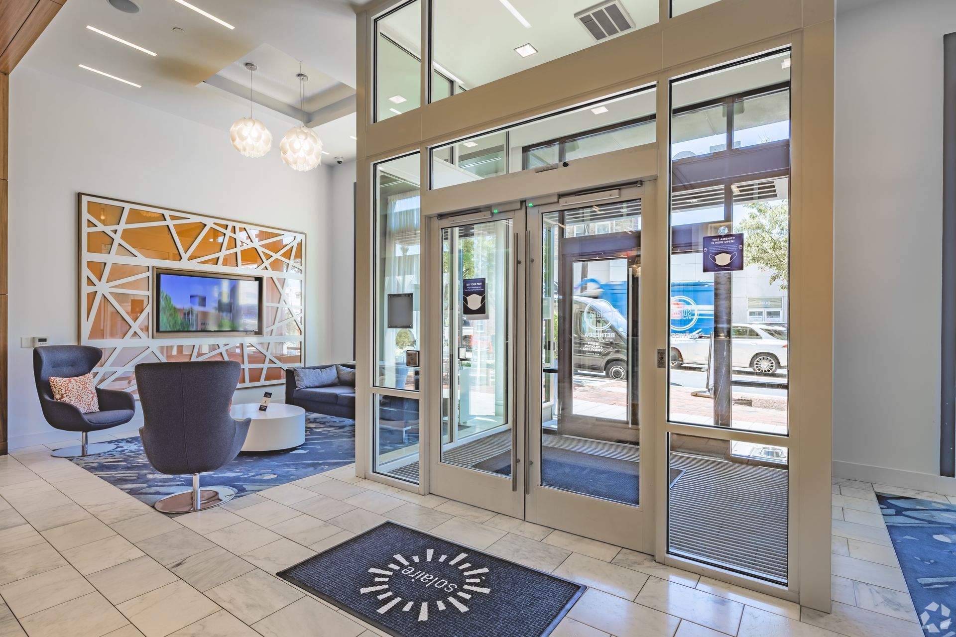 A large lobby with a lot of windows and chairs at Solaire 7077 Woodmont in Bethesda, MD.