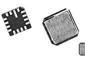 Close-up of two small electronic chip components, one black and one metallic, on a white background