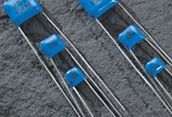 Blue slide fasteners clipped onto gray shoelaces on a textured fabric surface