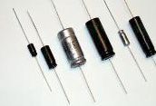 Assorted electronic components, including diodes and capacitors, laid out on a white background