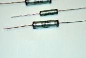 Two cylindrical glass electronic components with wire leads on a light background