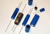 Assorted blue and brown electronic capacitors on a white background