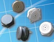 Assorted small round and square electronic speakers or buzzers in black, gray, and white on a blue background