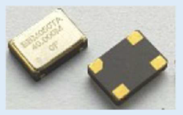 Two small electronic components, one metallic and one black with four gold corner pads.