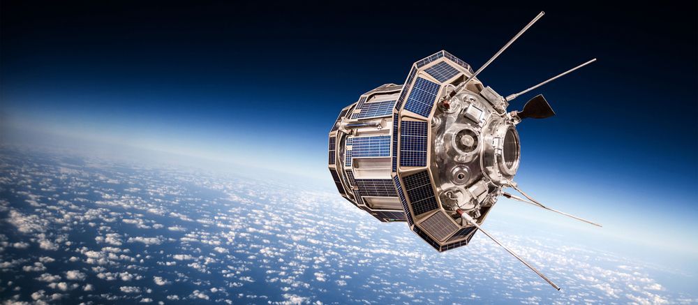 Satellite orbiting above Earth with blue horizon and visible solar panels in space