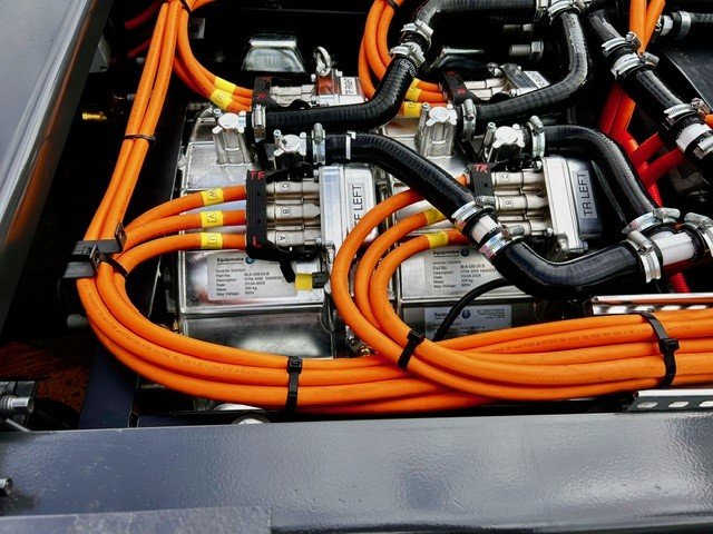 Orange high-voltage cables and electrical components inside a vehicle battery system