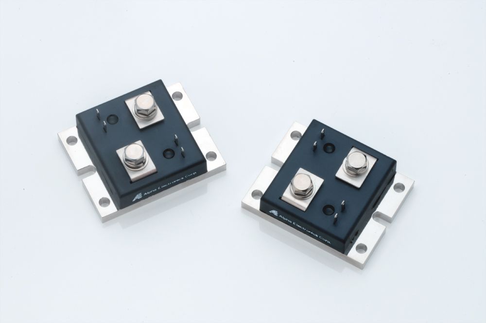 Two small black electronic modules with silver mounting tabs on a white background