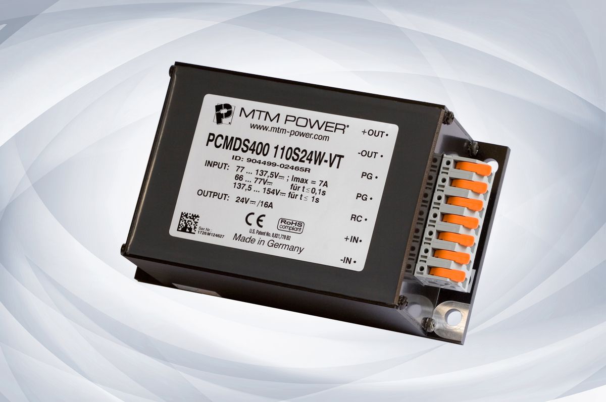 Black electronic control module with white label and orange connector terminals on a light background