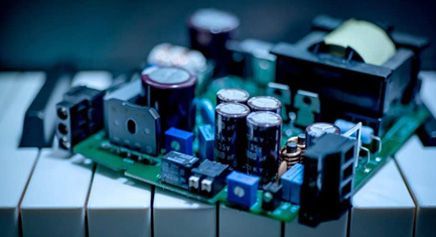 Small electronic circuit board with capacitors, connectors, and components on a tiled surface