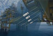 Oil platform with metal structures and pipes over blue water, with a ship partially visible nearby