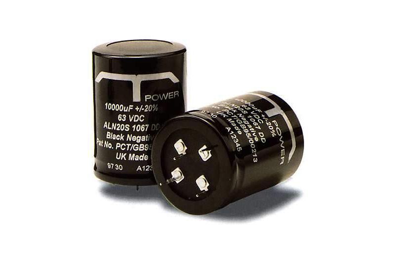 Two black cylindrical electronic capacitors with white text, one lying on its side