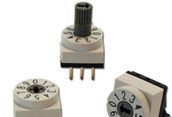Three small rotary dial components with numbered faces and metal pins on a white background