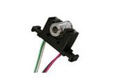 Close-up of a small black electrical switch with green and pink wires attached