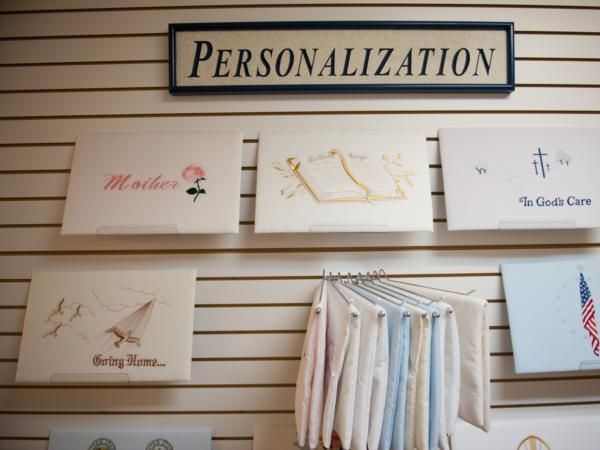 Personalization wall display with engraved plaques and hanging shirts on slat wall