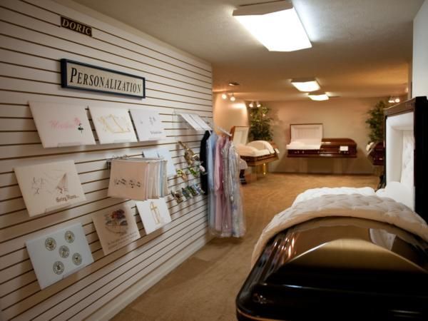 Interior of a salon display area with framed posters, hanging robes, and massage beds under warm lighting