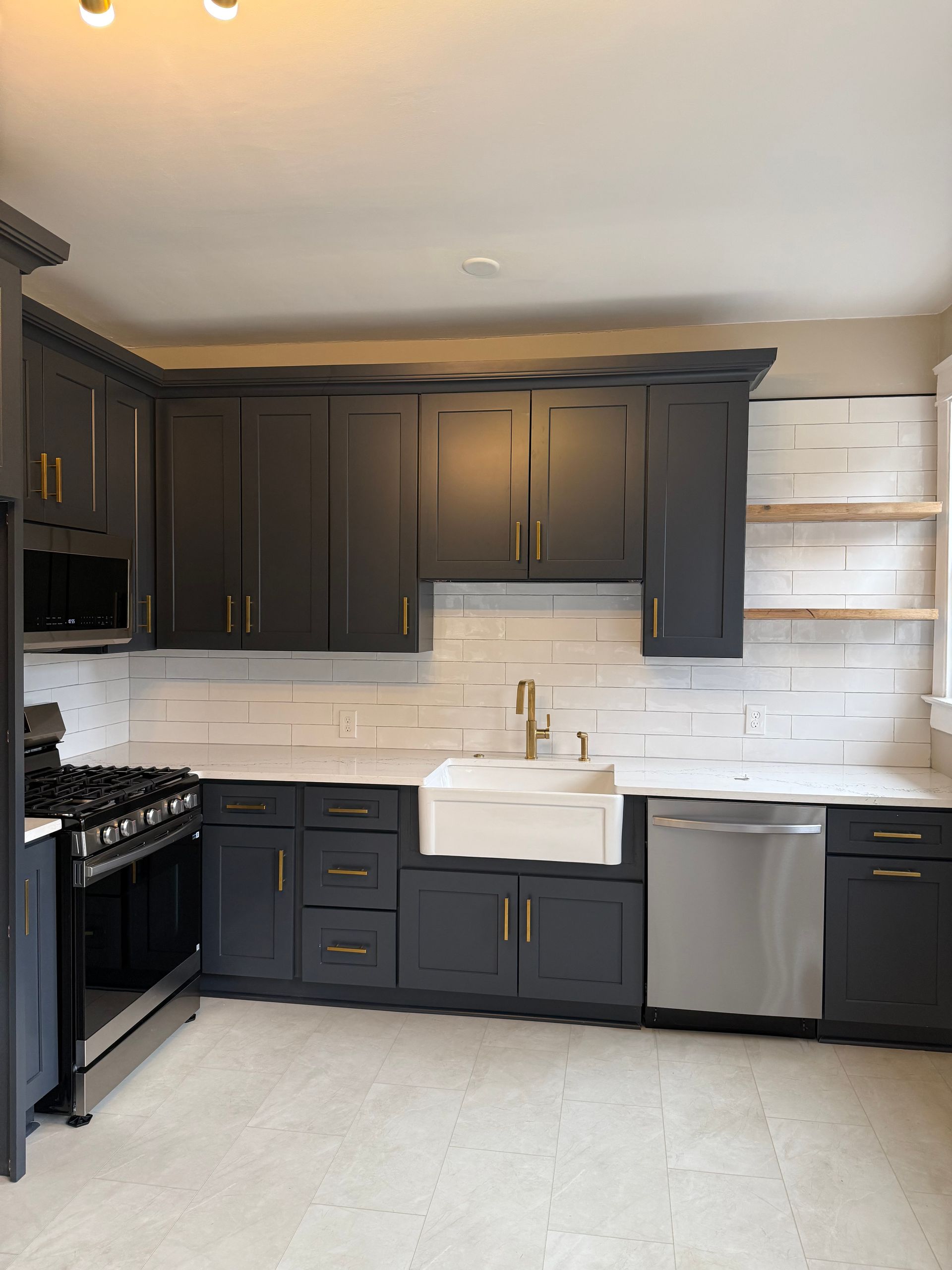 A kitchen with black cabinets and a white sink