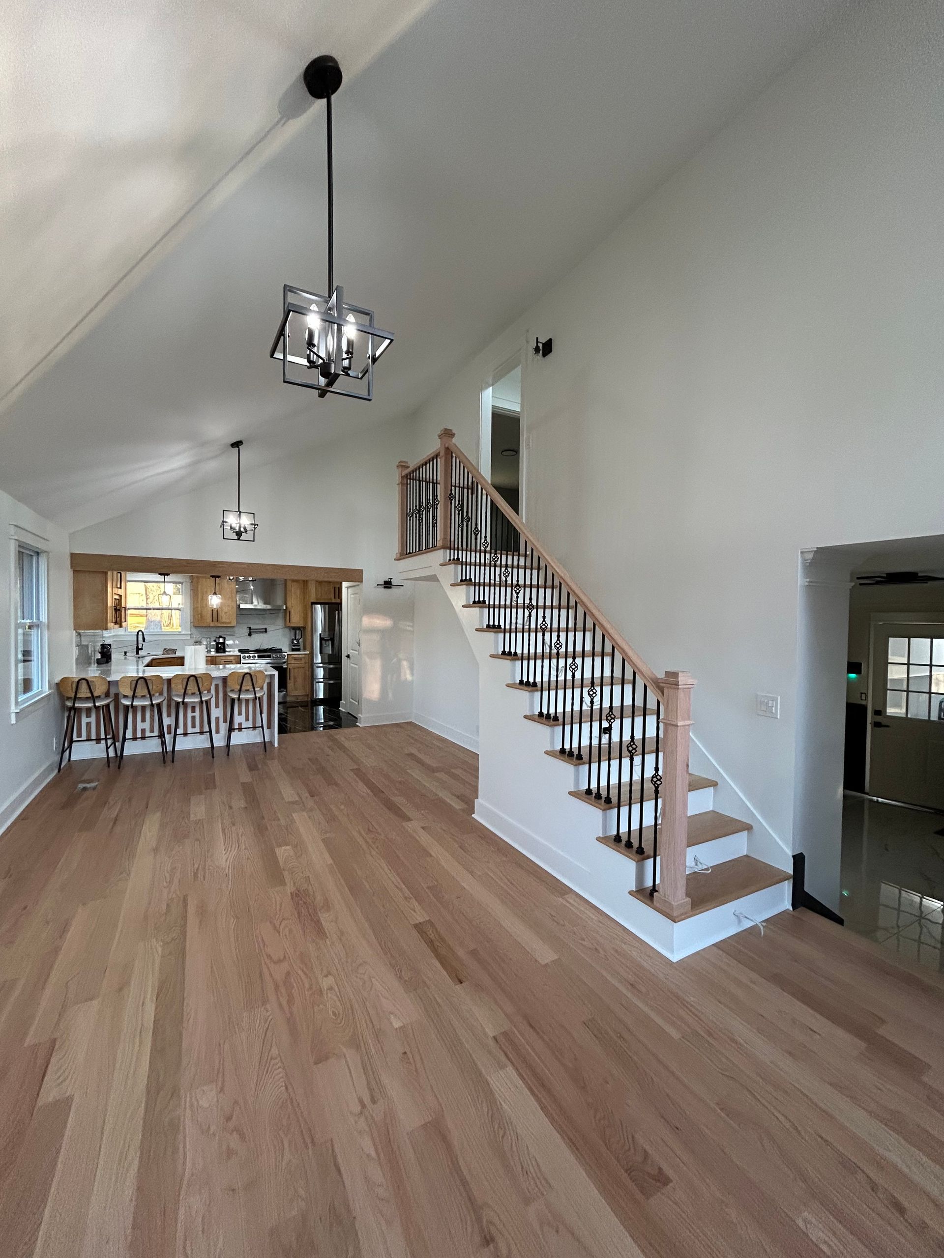 A living room with hardwood floors and stairs leading up to the second floor