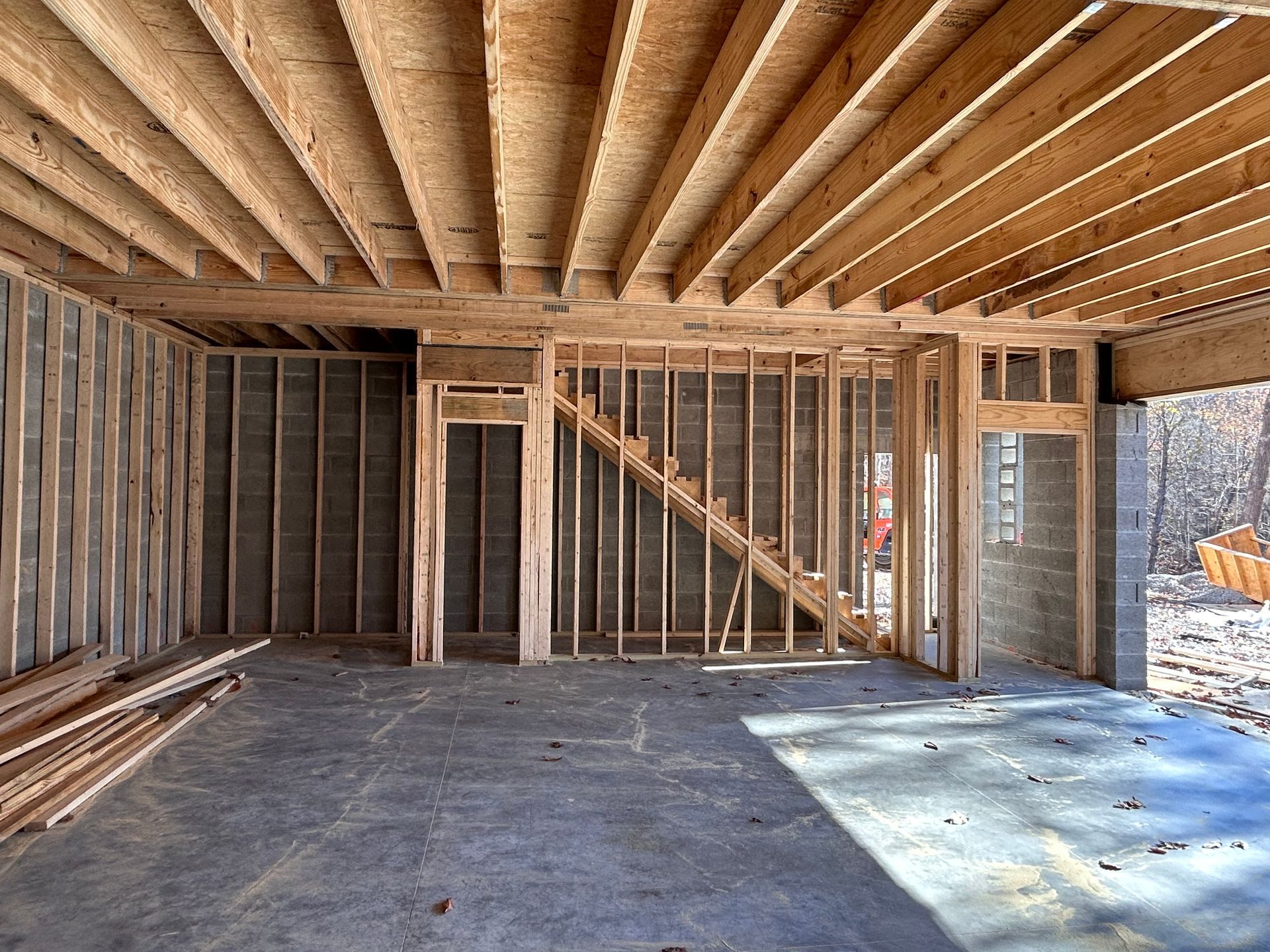 A garage under construction with wooden beams and a staircase.