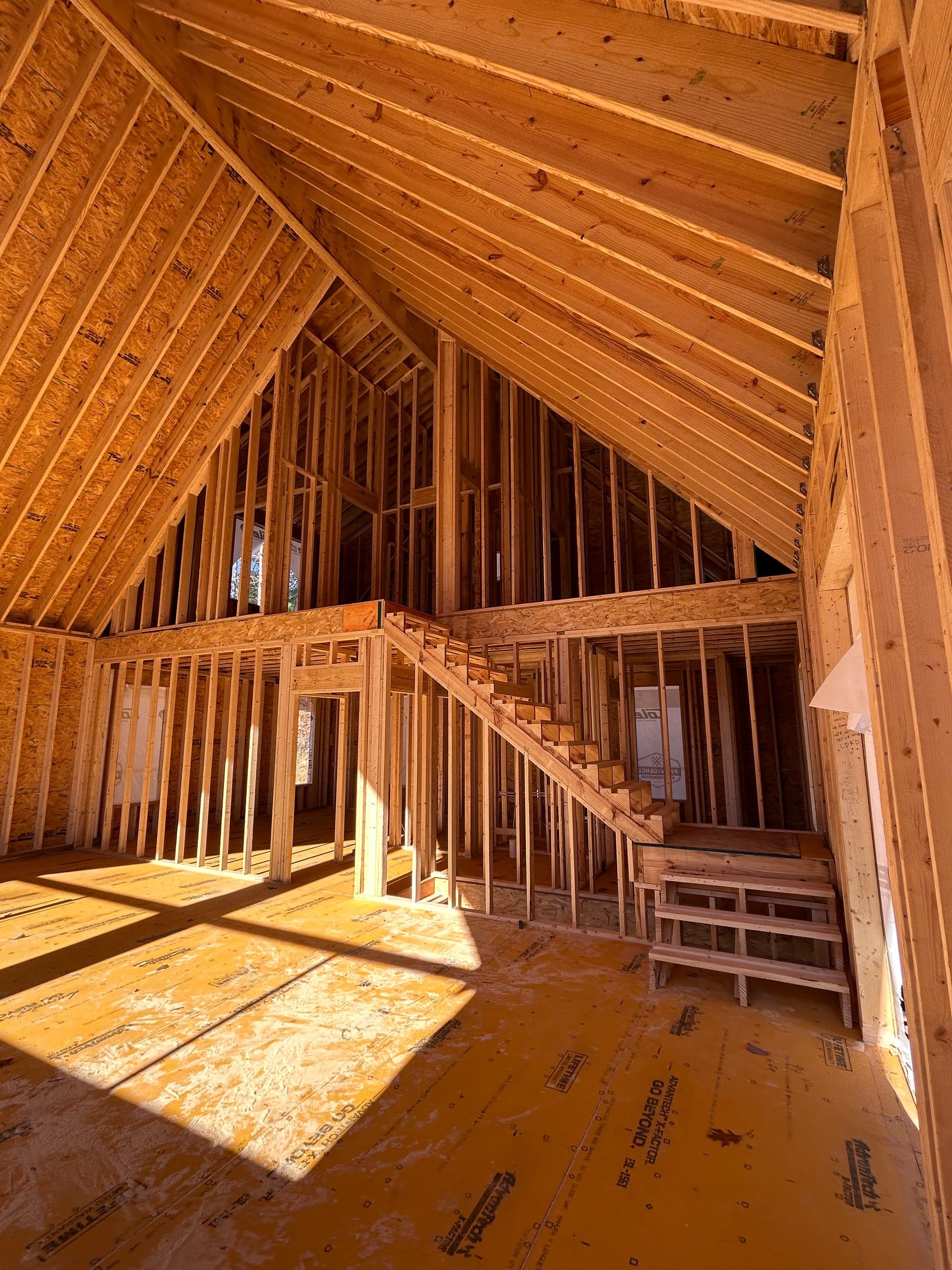 A house is being built with a vaulted ceiling and stairs.