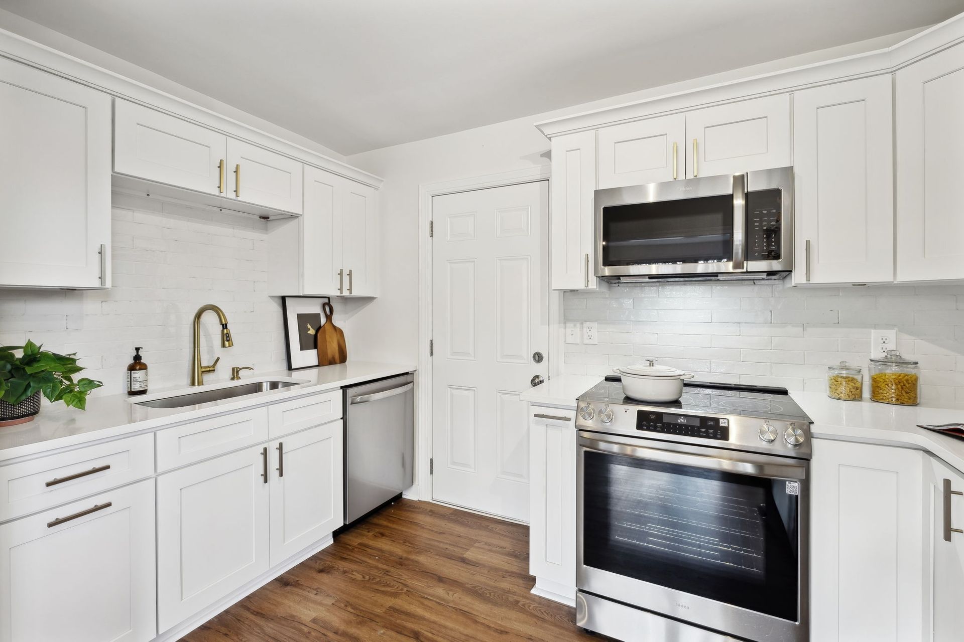 A kitchen with white cabinets and stainless steel appliances.