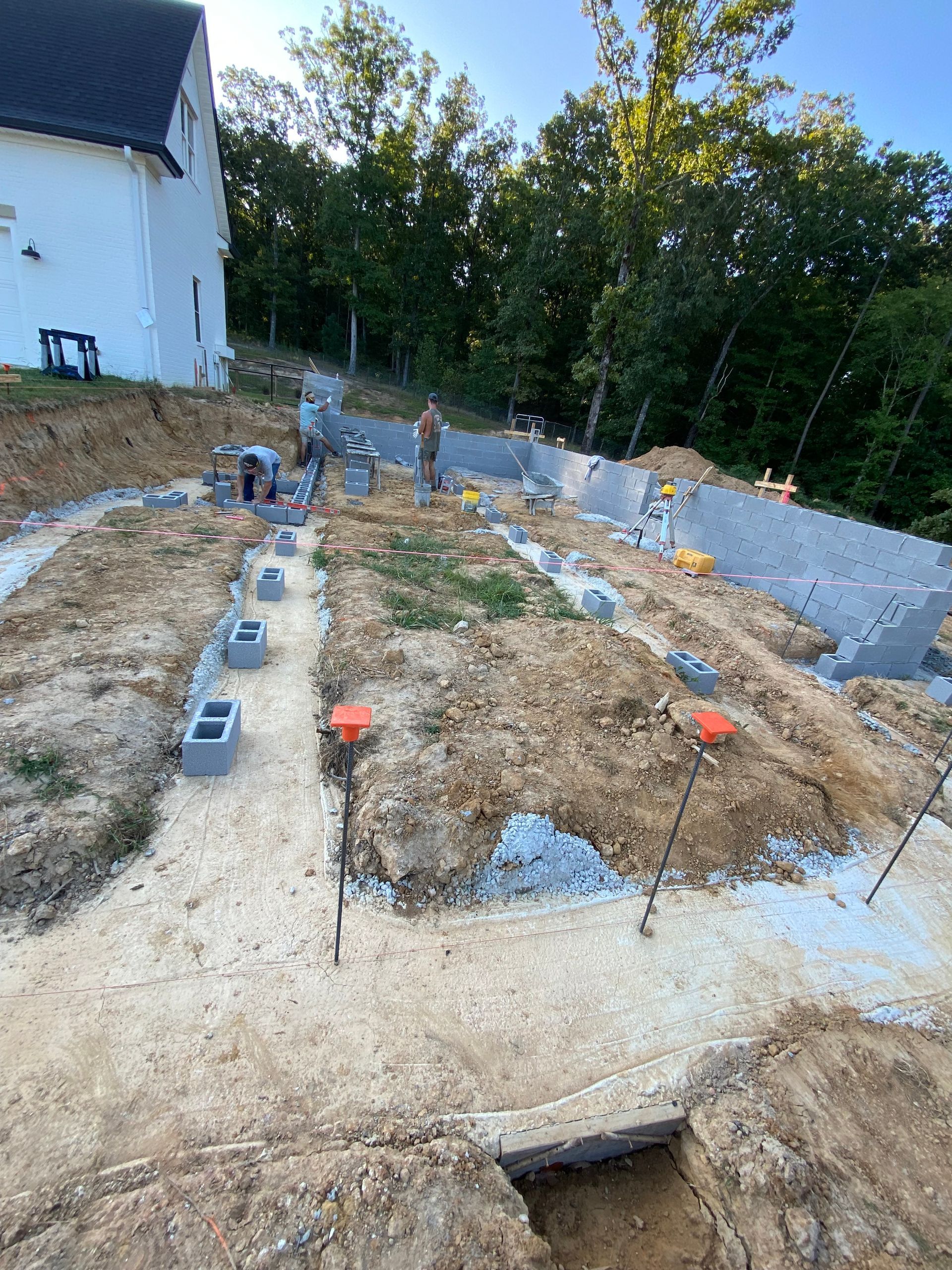 A construction site with a white house in the background.