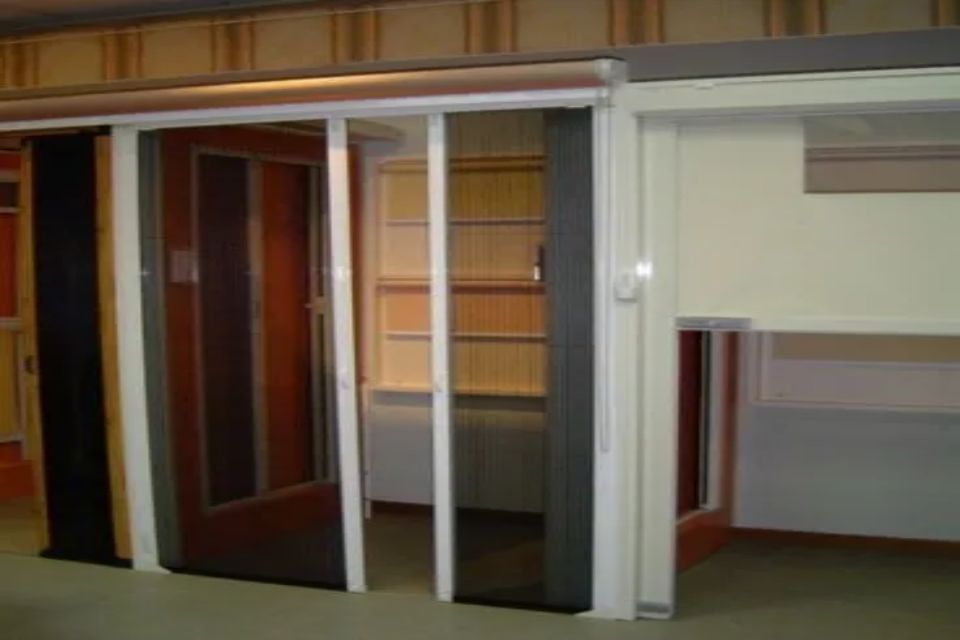 Porte scorrevoli in vetro con colori e texture diverse, in uno showroom.