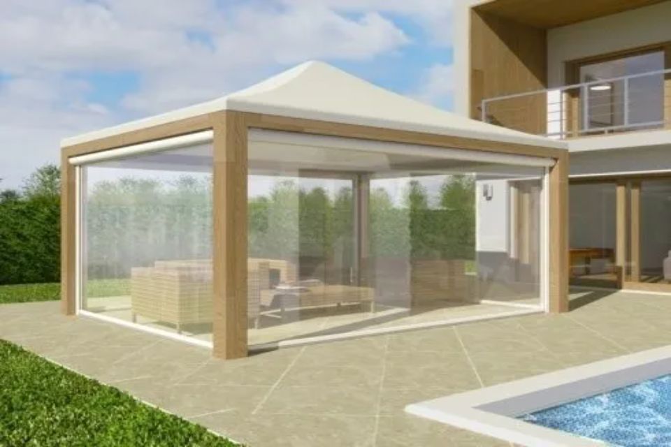 Gazebo con pareti in vinile trasparente e tetto color cuoio vicino a una piscina e a una casa moderna.