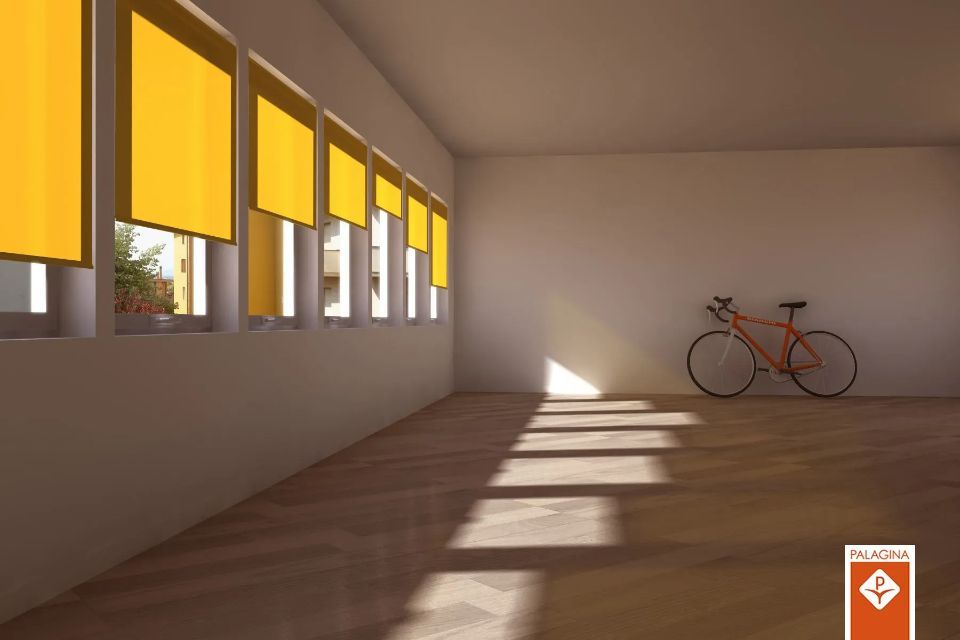 Stanza vuota con tende gialle, luce solare e una bicicletta rossa.