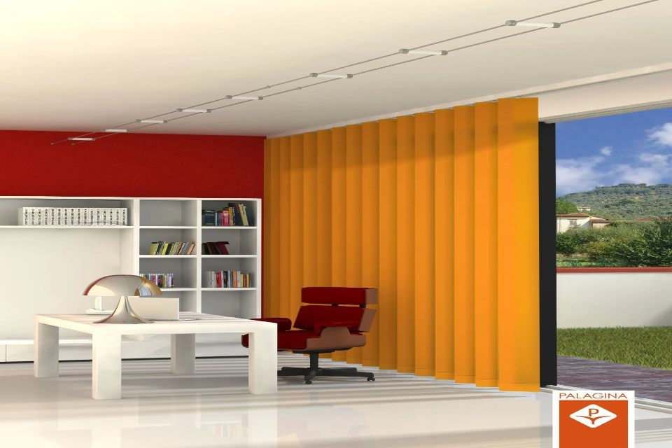 Moderno spazio ufficio con tende verticali arancioni, parete decorativa rossa, mobili bianchi e vista sugli alberi verdi.