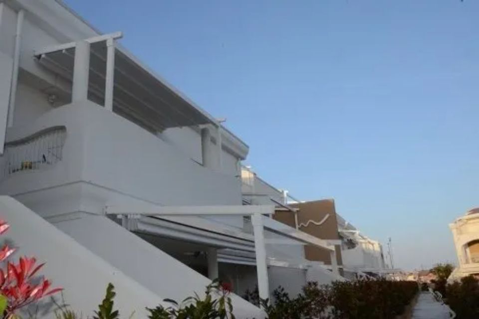 Edifici bianchi con tende da sole e cielo azzurro.