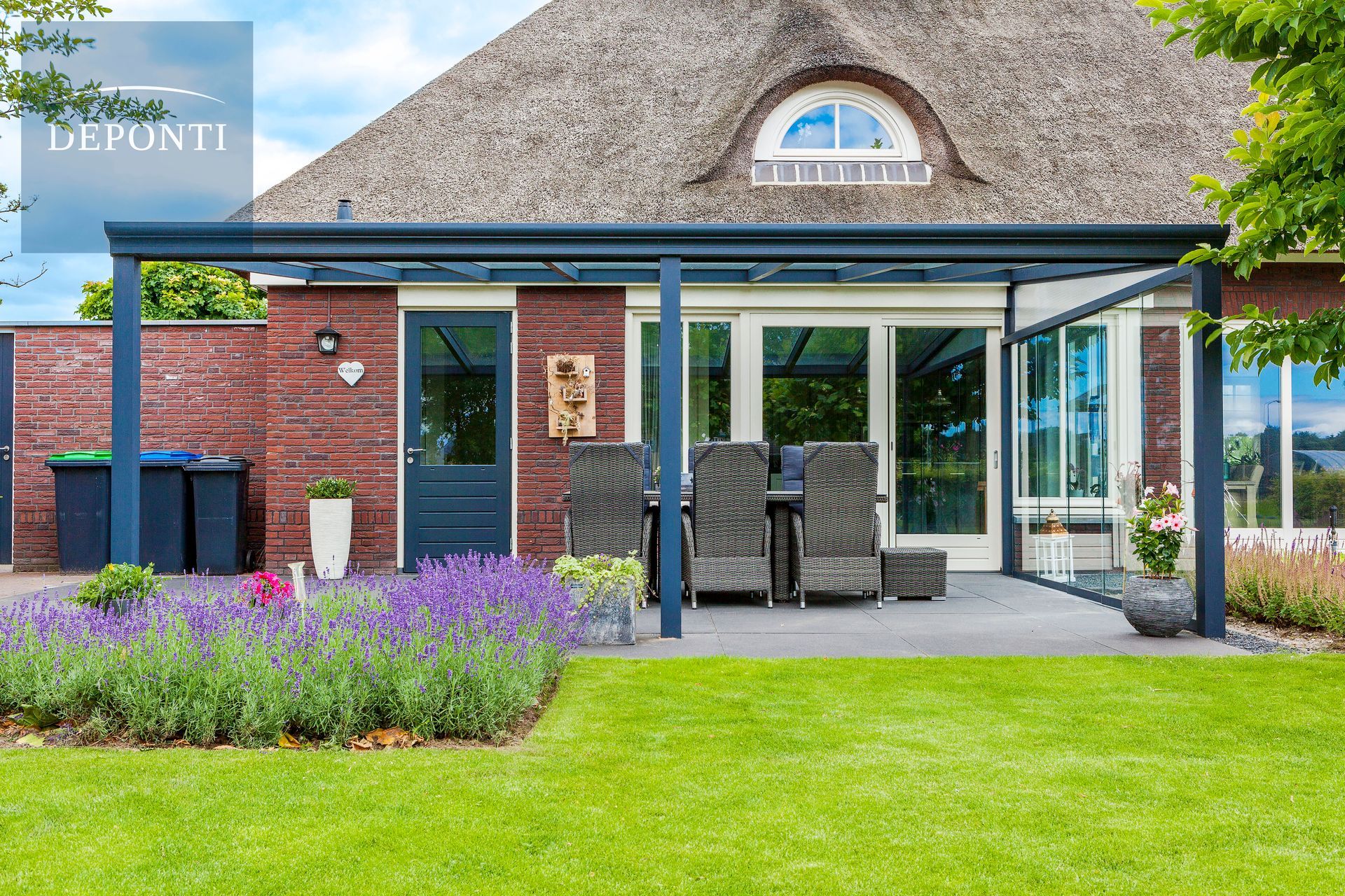 Deponti aluminium veranda with glass sliding panels to the side and a table and chairs under the canopy