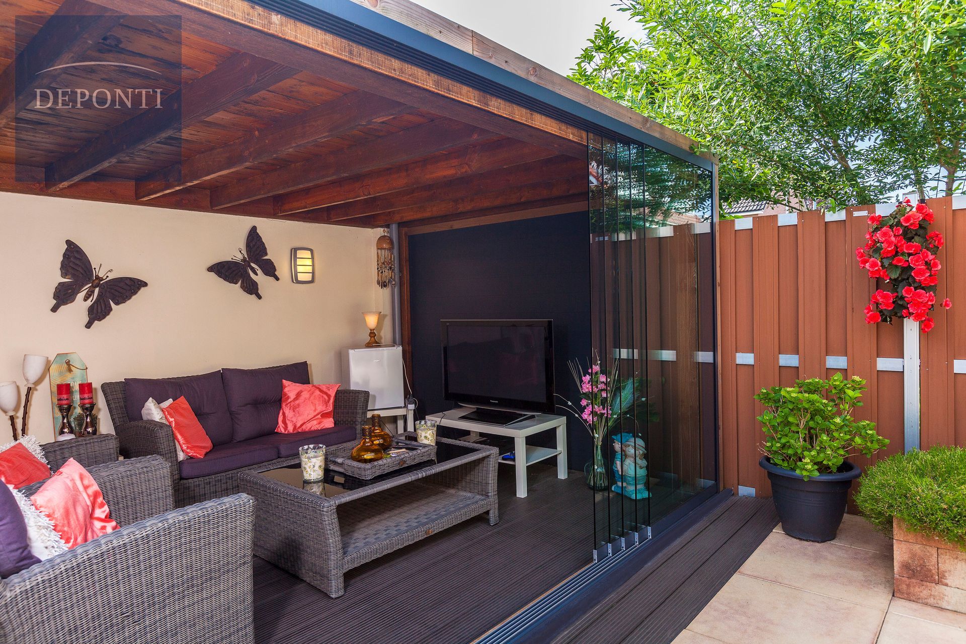 a patio with a couch and chairs and a television
