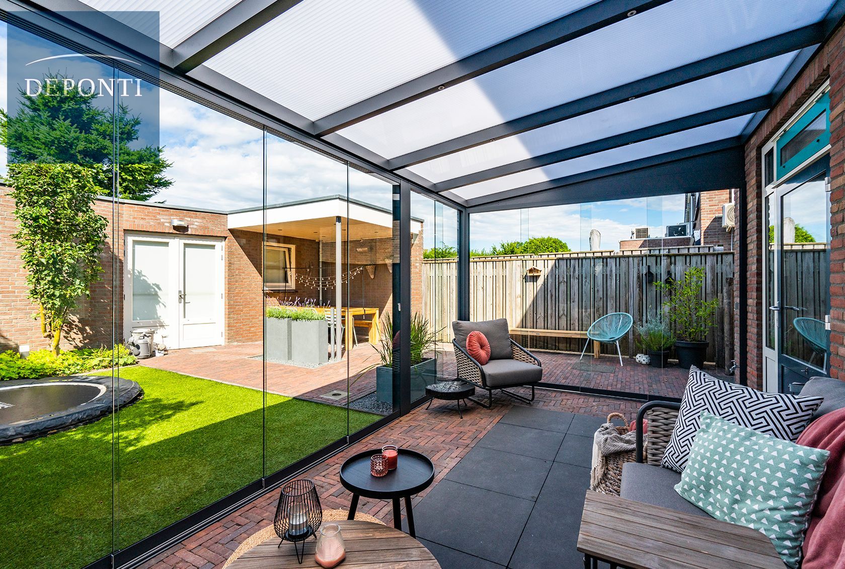 Premium Deponti aluminium veranda with glass sliding panels to the side and front and a table and chairs under the canopy
