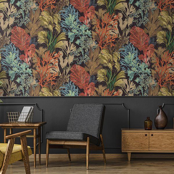 a living room with a chair and a table with a colorful wallpaper on the wall