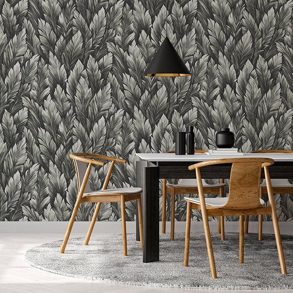 a dining room with a table and chairs in front of a wall with leaves on it .