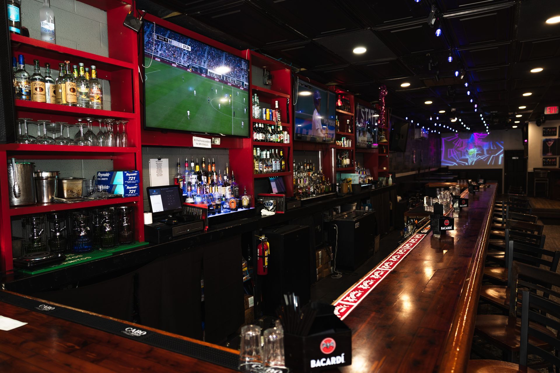A bar with a lot of televisions on the wall
