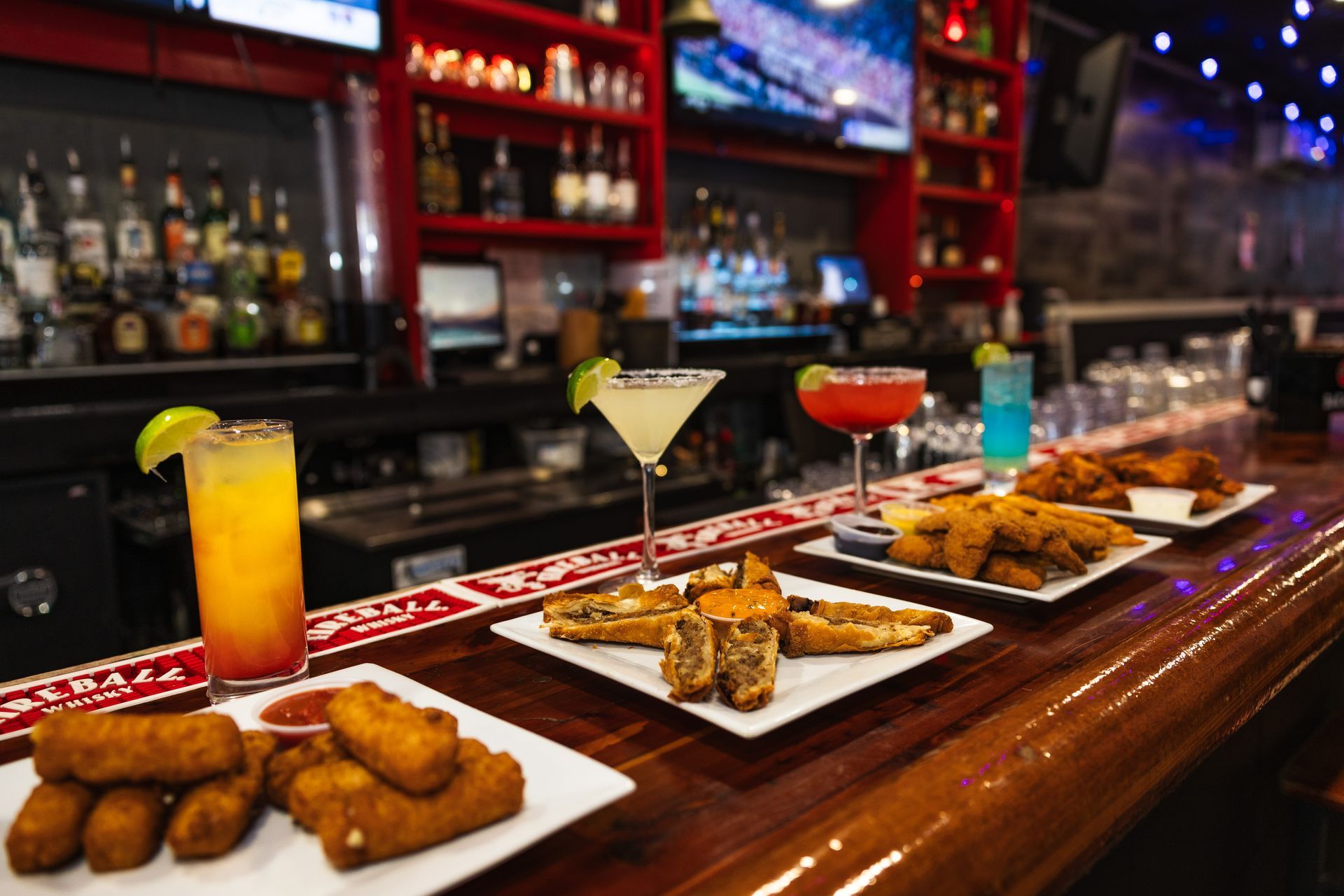 A bar with plates of food and drinks on it.