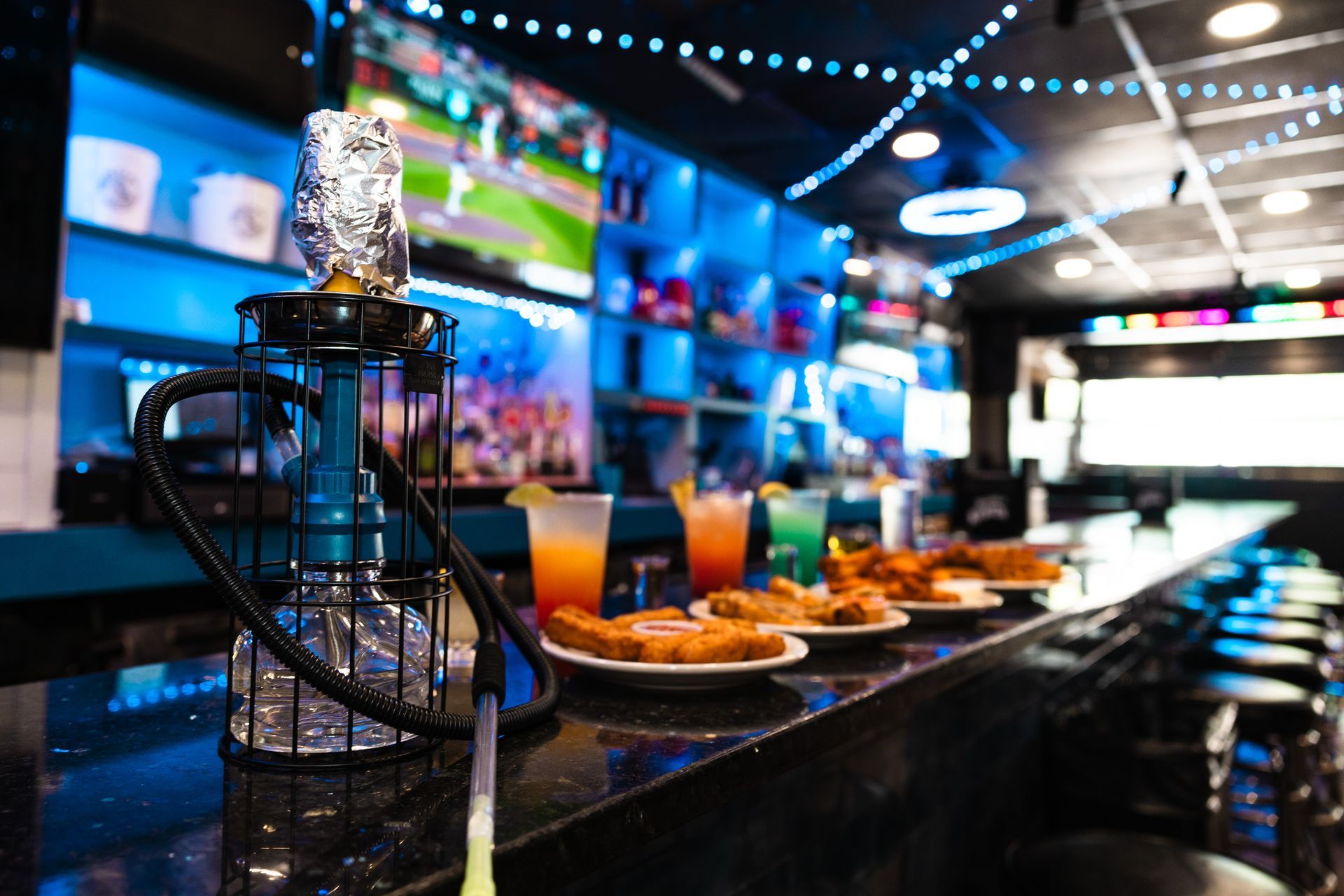 A hookah is sitting on a bar next to plates of food.