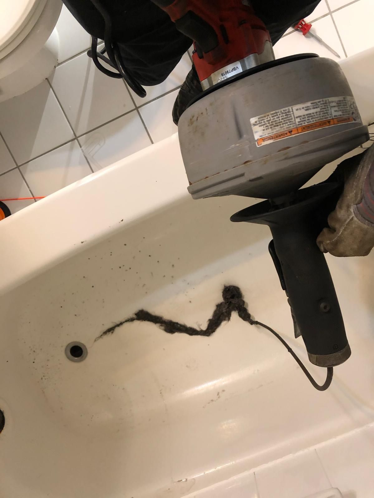 Main drain line unclogged by licensed Oakville plumber – large hair blockage removed from bathtub drain during emergency service
