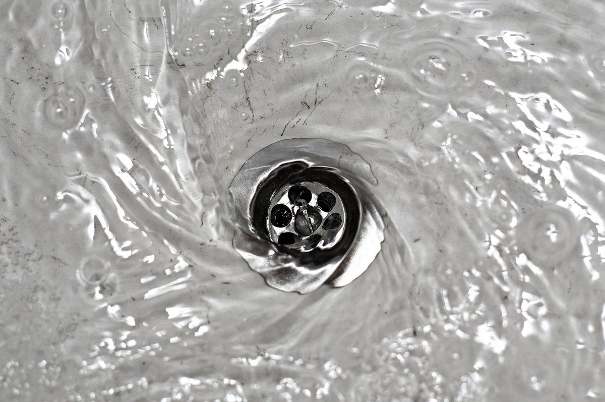 Clean commercial floor drain with flowing water after powerflushing service in Oakville restaurant
