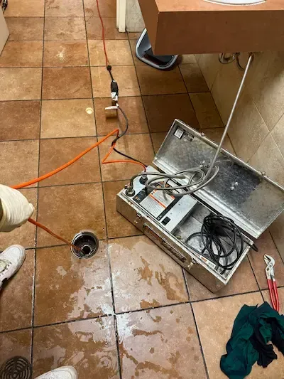 Commercial floor drain powerflushing service by 17 Plumbing using drain cleaning equipment to clear a blocked floor drain in a restaurant.