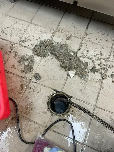 emergency plumber oakville repairing floor drain backup with debris and blockage