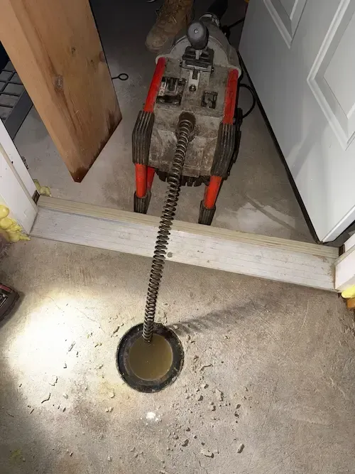 Accessing the main cleanout in the basement. This is where we start on most main line calls — it gives us a direct line into the pipe without opening up walls or flooring.
