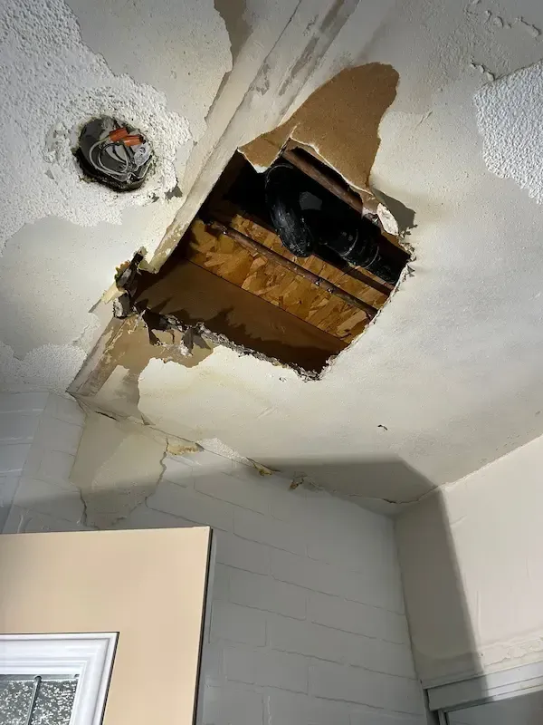 Emergency plumber in Oakville repairing burst pipe inside ceiling after water leak damage