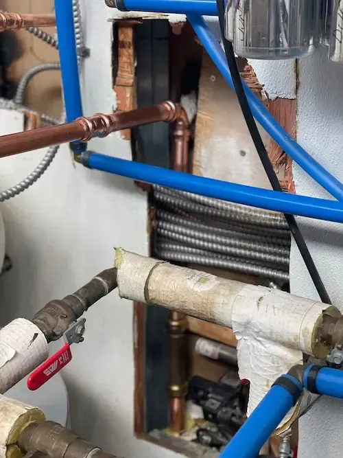 Close-up view of newly soldered copper pipe during emergency plumbing repair at airport facility
