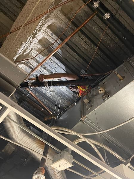 17 Plumbing plumber performing commercial pipe replacement above ceiling in building, ensuring proper leak repair and secure fitting