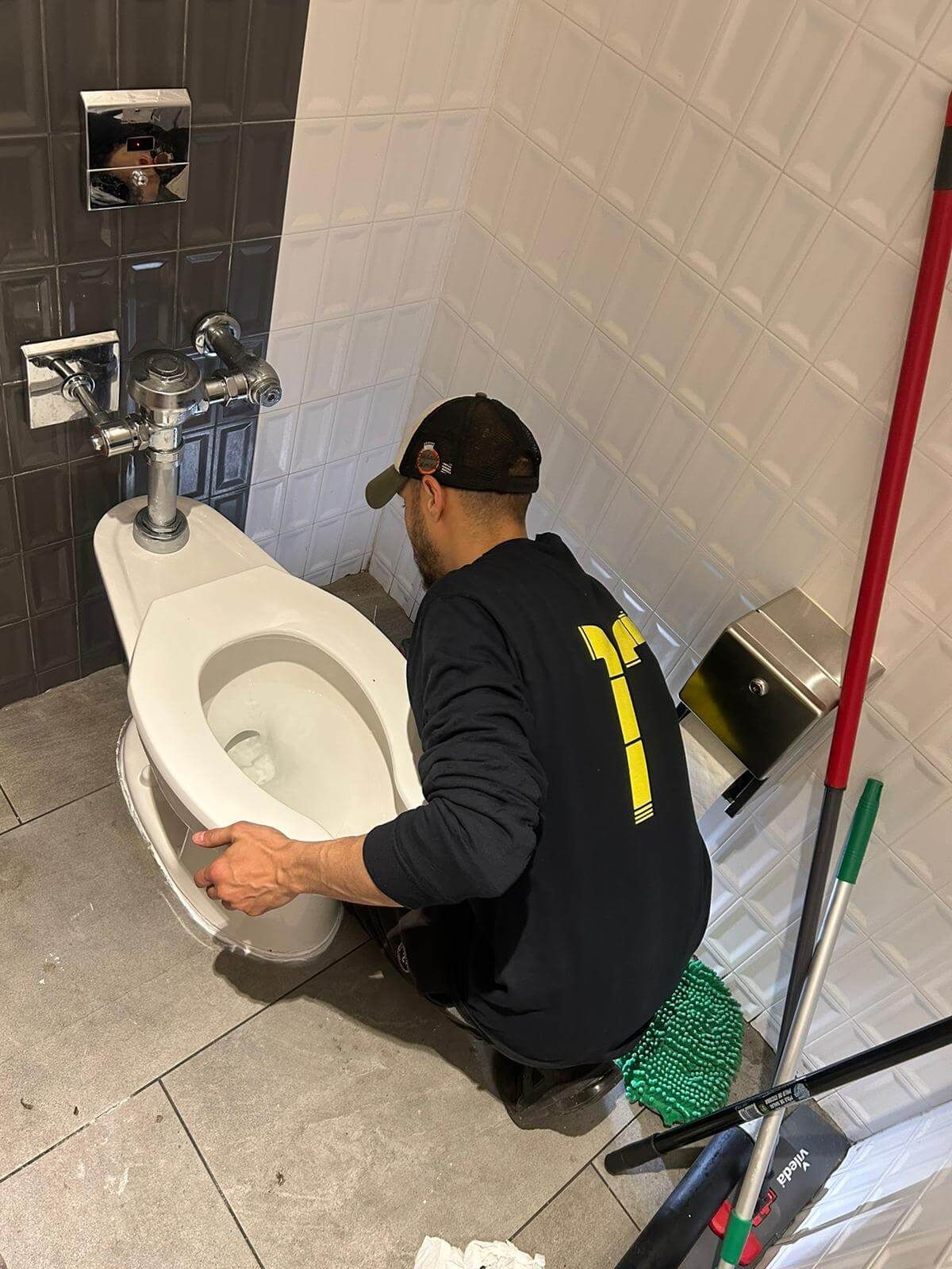 Oakville plumber removing a toilet to access and clear a deeper drain blockage after an overflow.