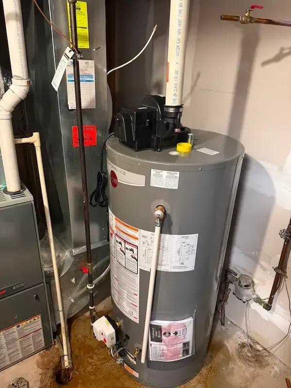 Licensed plumber installing a new water heater in an Oakville home, showing professional pipe and valve connections during installation.